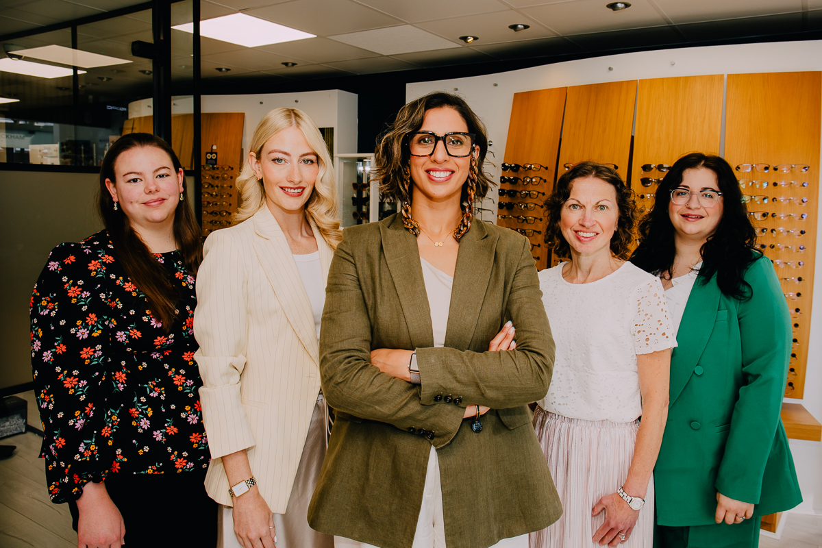 A practice management team portrait, everyone is smiling and looking at the camera.