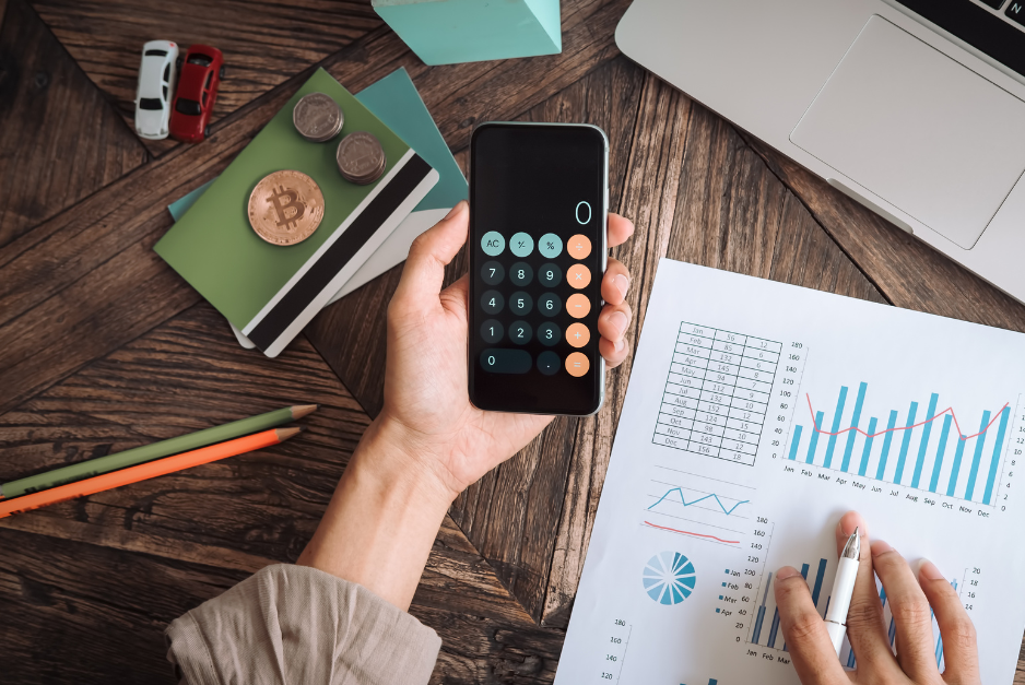 Person reviewing business finances with a calculator and reports, representing cost savings for independent optical practices.